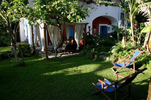a yard with two lawn chairs and a house at Dimora Coloniale B&B in Ischia
