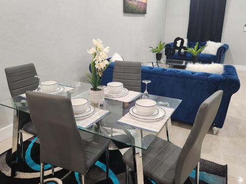 une salle à manger avec une table et un canapé bleu dans l'établissement The Hide Away, à Nassau
