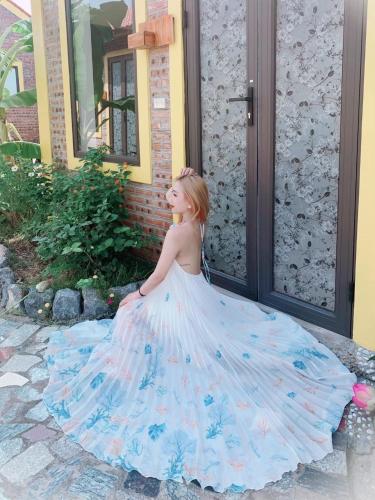 a young girl in a wedding dress sitting outside a house at Ninh Binh Royal Homestay in Ninh Binh