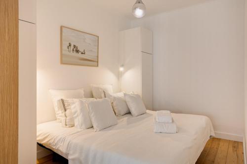 a bedroom with a white bed with white pillows at Alfama Chic Penabuquel3 in Lisbon