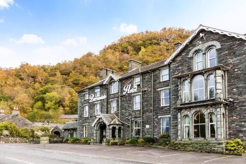 an old stone building in front of a mountain at The Borrowdale Hotel in Keswick