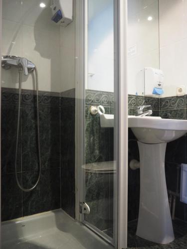 a bathroom with a shower and a sink at Hostal Acella in Pamplona