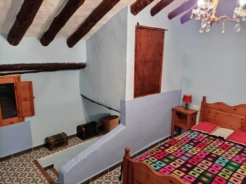 1 dormitorio con cama y lámpara de araña en Acogedora casa de pueblo, con todas las comodidades, en Moratalla
