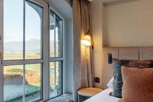 a bedroom with a bed and a large window at The Borrowdale Hotel in Keswick