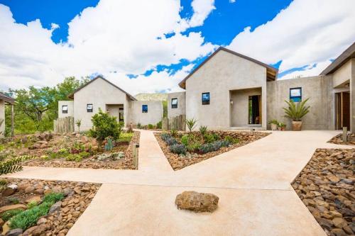a house with a stone driveway in front of it at Makanyane Lodge in Matlhagame