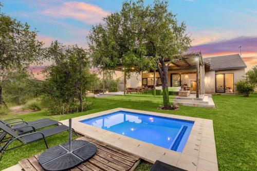 a backyard with a swimming pool and a house at Makanyane Lodge in Matlhagame