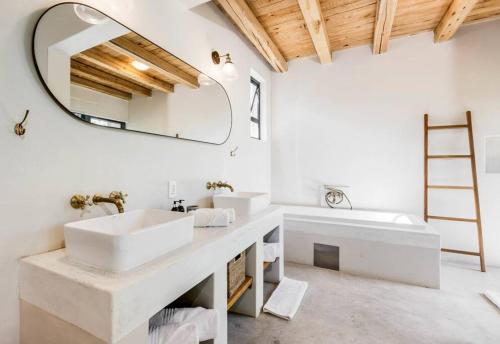 a bathroom with two sinks and a mirror at Makanyane Lodge in Matlhagame