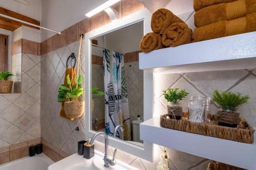 La salle de bains est pourvue d'un lavabo, d'un miroir et de serviettes. dans l'établissement Stone villa Halepa with panoramic view., à Néon Khoríon