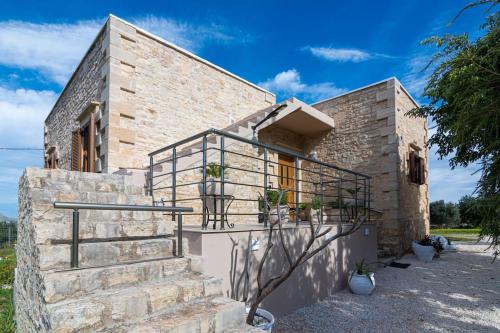 a stone house with a staircase in front of it at Stone villa Halepa panoramic view, private pool,big garden & quiet in Néon Khoríon