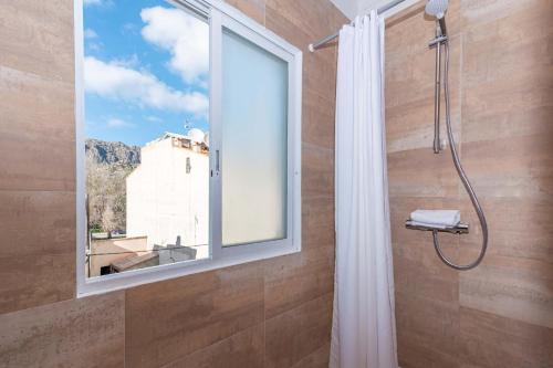 a bathroom with a window and a shower with a shower curtain at On The Beach Voramar by Sealand Villas in Port de Pollensa