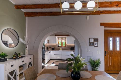a kitchen and living room with an archway at Stone villa Halepa with panoramic view. in Néon Khoríon