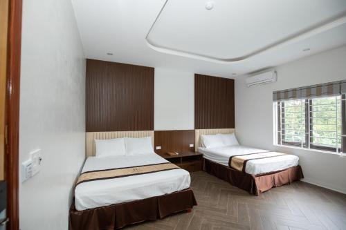 um quarto de hotel com duas camas e uma janela em Nhà Nghỉ Ngọc Anh em Nghĩa Lộ