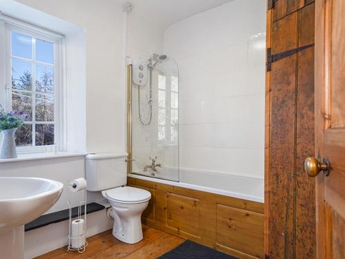 a bathroom with a toilet and a sink and a tub at Pass the Keys Cosy Cottage in Corris One wellbehaved dog welcome in Machynlleth