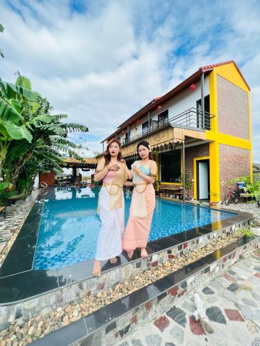two women standing in front of a swimming pool at Ninh Binh Royal Homestay in Ninh Binh