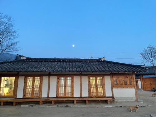 a chinese building with a dog in front of it at Hanok Stay - JukRokJungSa in Gurye