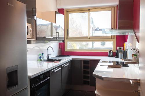 a kitchen with white counter tops and a window at Superbe appartement avenue de Champagne + parking in Épernay