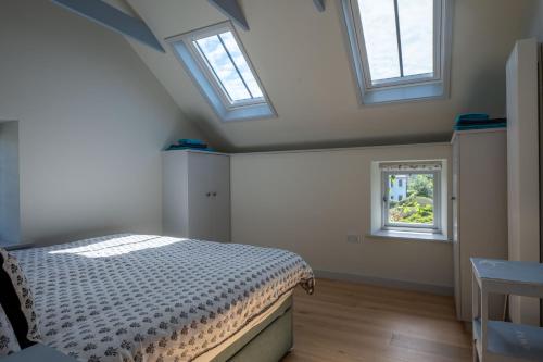 1 dormitorio con 2 tragaluces y 1 cama. en Converted Hay-loft with Stunning Countryside Views, en Haverfordwest