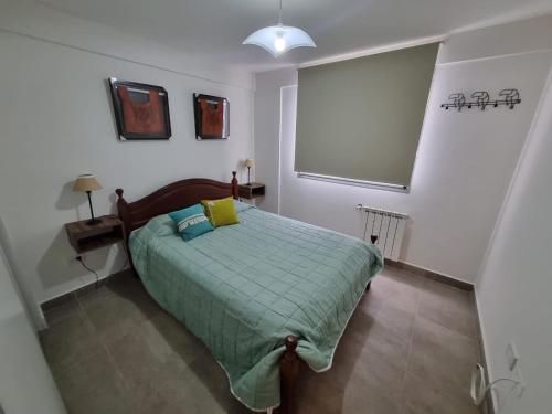 1 dormitorio con 1 cama con edredón verde en UMA en Salta