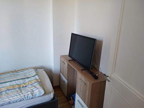 um quarto com uma televisão numa cómoda de madeira em VIP Appartment Centre Payerne em Payerne