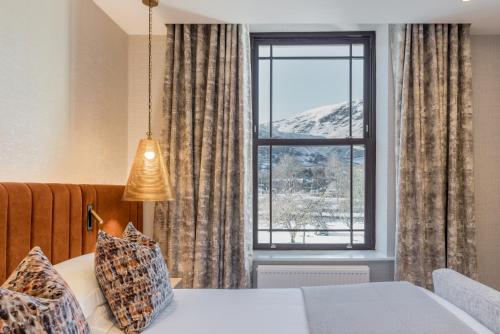 a bedroom with a bed and a large window at The Inn On The Lake in Glenridding