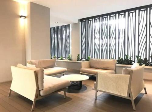 a living room with couches and chairs and a table at Teega Suites Seaview by VDO Homestay in Nusajaya