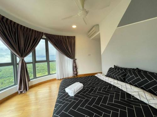 a bedroom with a bed and large windows at Teega Suites Seaview by VDO Homestay in Nusajaya
