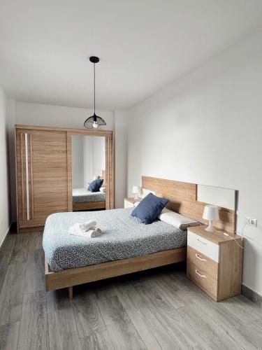 a bedroom with a large bed and a mirror at Apartamentos CEO - Naranja in Ronda