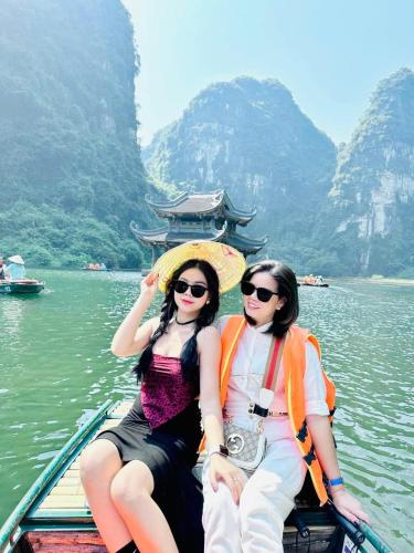 two women sitting in a boat on the water at Ninh Binh Royal Homestay in Ninh Binh