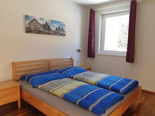 a bed with blue pillows on it in a bedroom at Ferienwohnung Bergsteiger in Strassen