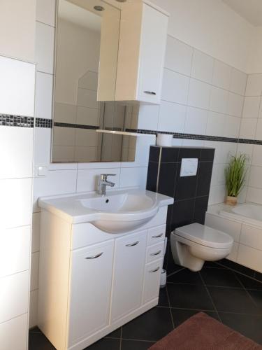 a white bathroom with a sink and a toilet at Ferienwohnung Bergsteiger in Strassen