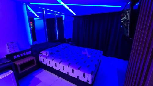 a room with a bed and a blue light at Sense Motel in Porto Alegre