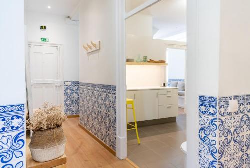 una cucina con piastrelle bianche e blu sulle pareti di Casa St Yves - Sunny flat in Setúbal on Av Luisa Todi a Setúbal