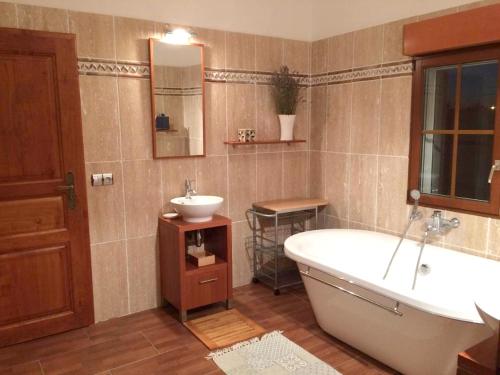 een badkamer met een bad en een wastafel bij Villa de 6 chambres avec piscine privee jardin clos et wifi a Saint Cyr sur Loire in Saint-Cyr-sur-Loire