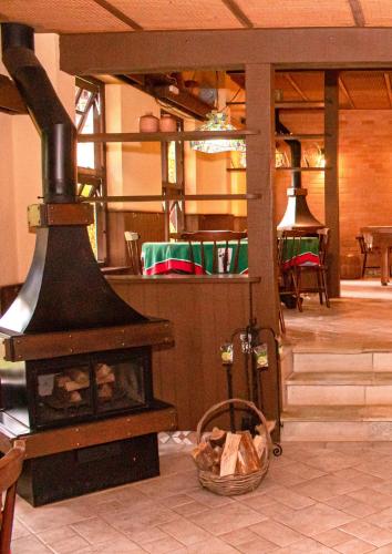 a fireplace in a room with a table and chairs at Pousada O Cantinho da Raposa in Monte Verde