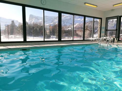 a swimming pool with a view of the mountains at Chalet Le Dévoluy, 3 pièces, 6 personnes - FR-1-504-634 in Superdevoluy