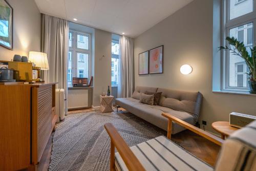 a living room with a couch and some windows at Hotel Mayfair in Copenhagen
