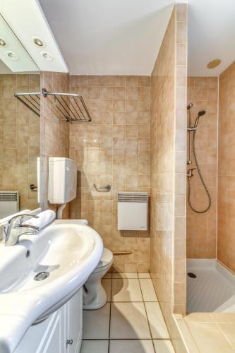 une salle de bain avec une douche, un lavabo et des toilettes dans l'établissement SOWELL RESIDENCES Les Lauriers Roses, au Cap d'Agde