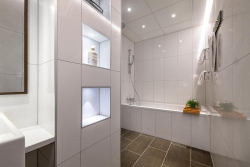 un bagno bianco con vasca e lavandino di Hotel Mayfair a Copenaghen