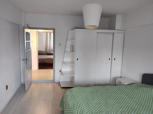 1 dormitorio con cama y armario blanco en Ultracentral Ploiesti Apartment-Free Private Parking, en Ploieşti