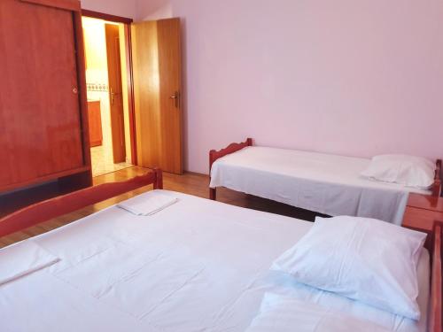 a room with two beds and a door with a window at BetaNovalja in Novalja