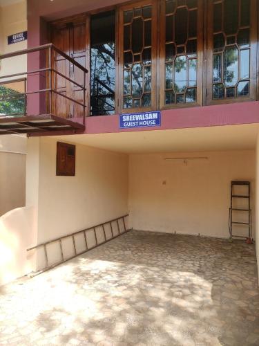 an empty room with a balcony and a building at Sreevalsam Guest House in Trivandrum