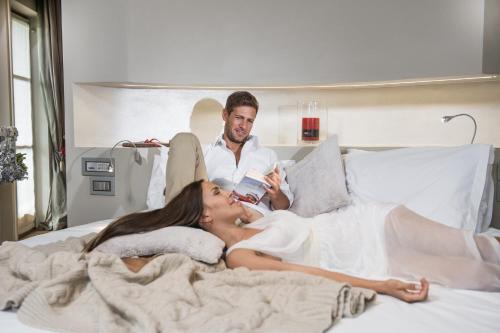 a man and a woman laying on a bed at Bio Hotel Hermitage in Madonna di Campiglio