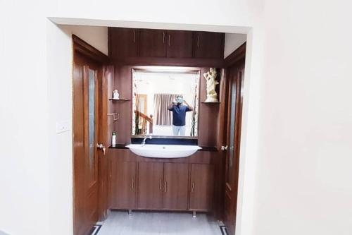 uma pessoa a tirar uma foto de um espelho de casa de banho em Luxurious 5 BHK Duplex in Kukatpally em Hyderabad