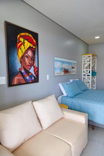 a living room with a couch and a painting on the wall at Pousada Guaricana in Pontal do Paraná