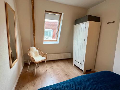 a bedroom with a bed and a dresser and a chair at Vakantiehuis Achter de Duinen in Castricum