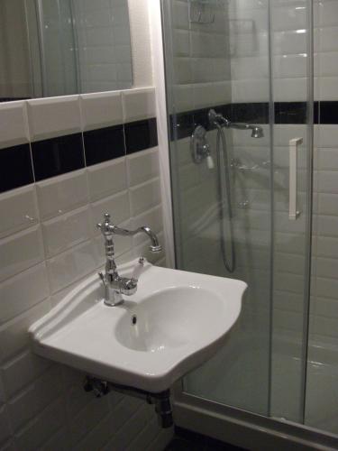 a bathroom with a sink and a glass shower at volterracentro in Volterra