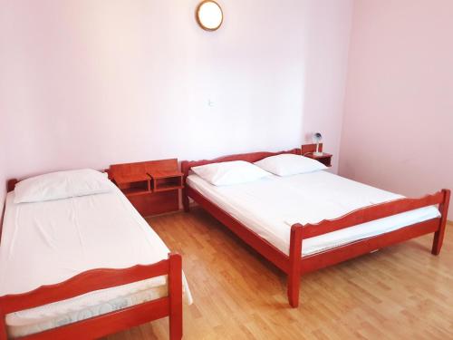a bedroom with two beds and a clock on the wall at BetaNovalja in Novalja
