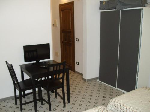 a room with a desk with a computer and chairs at volterracentro in Volterra