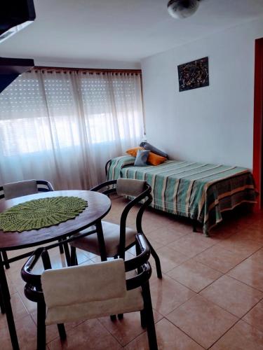 Cette chambre comprend une table, un lit, une table et des chaises. dans l'établissement Depto. El duende, à Olavarría