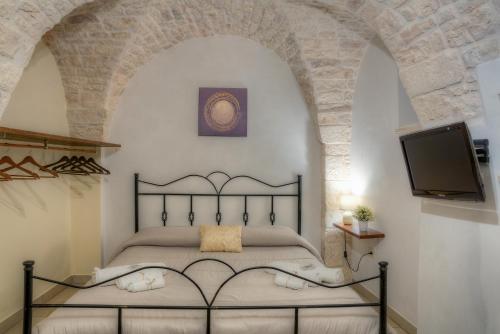 a bedroom with a bed and a flat screen tv at Il Trulletto in Montalbano